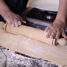 Para preparar las empanadas, enharinar una superficie plana, extender la pasta de hojaldre con un rodillo, hasta dejarla de medio centímetro de grosor.