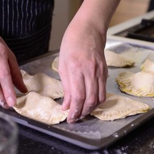 Cerrar por la mitad para formar la empanada. Sellar las orillas con un tenedor. Colocar en una charola de horno con papel encerado y refrigerar 30 minutos.