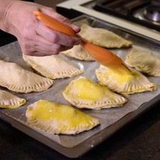 Sacar del refrigerador y barnizar con la yema encima de la empanada, meter al horno y hornear a 300 °F (150°C) durante 15 minutos o hasta que estén doradas.