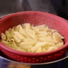 Pelar el pepino, picarlo en cubos pequeños al igual que el queso feta. Picar finamente la cebolla morada. Cortar las aceitunas en cuatro partes y los tomates cherry en dos partes y reservar. Para cocer la pasta, poner mucha agua a hervir, agregar sal y cuando recupere el hervor añadir la pasta. Dejar cocer de 7 a 11 minutos hasta que esté al dente, firme por dentro y suave por fuera. Escurrir y reservar.
