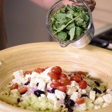 Añadir aceitunas en cuartos, queso feta en cubos pequeños, jitomates cherry partidos por la mitad y arúgula. Revolver bien.