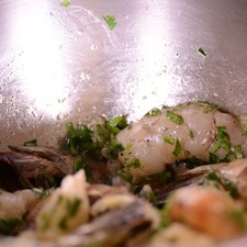 Retirar la cáscara, la cabeza y las patas de los camarones, dejando la cola para poderlos capear. Enjuagar con agua y dejar escurrir. Colocar los camarones ya pelados en un recipiente. Agregar el ajo molido, el perejil picado y el aceite de oliva.