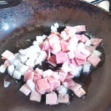 Calienta aceite y sofríe la cebolla y el jamón, es una rebanada de jamón por cada huevo.