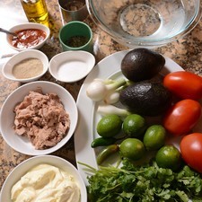 Ingredientes: hielo al gusto aceite de oliva al gusto 1 lata de atún 3 cucharadas de mayonesa pimienta blanca molida al gusto sal al gusto 1 pieza de chile chipotle adobado 1/4 manojo de cilantro 1 pieza de chile serrano 1 pieza de limón 1 diente de ajo 1 pieza de cebollita cambray 2 piezas de aguacate 3 piezas de jitomate guaje