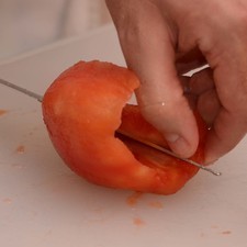 Cortar los jitomates haciendo un movimiento en forma de círculo para que quede la pulpa plana y descartar el corazón.