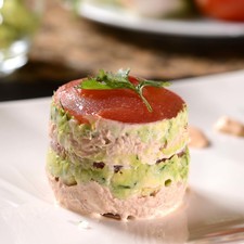Para montar el plato, colocar dentro del aro un círculo de jitomate, colocar encima una cucharada de atún y presionar con la cuchara para compactar. En seguida, agregar una cucharada de guacamole y compactar. Agregar otro círculo de jitomate y repetir las capas hasta terminar con un círculo de jitomate. Sacar el mil hojas del aro. Barnizar con un poco de aceite de oliva. Colocar en un plato adornado con unas gotas de salsa de mayonesa con chipotle y un poco de guacamole.