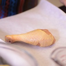 Hay muchas maneras de poner a cocinar los mixiotes, pueden usar papel aluminio, hoja de plátano, papel encerado o bolsas para mixiotes. Colocar en el papel encerado una pieza de pollo.