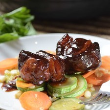 Servir las costillas sobre una cama de verduras.