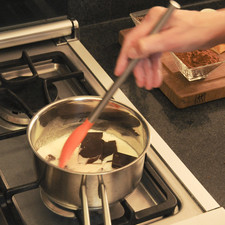 Trocear el chocolate. Verter la crema para batir en un recipiente y llevar a fuego medio sin dejar de mover, utilizando una cuchara de palo o un miserable hasta que empiece a hervir. Agregar el chocolate troceado y bajar al mínimo el fuego, mezclar hasta que esté derretido por completo el chocolate.