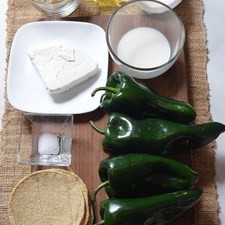 Ingredientes para para las rajas: 1/4 pieza de cebolla blanca 1/2 cucharita de sal 100 gramos de queso manchego 1/2 taza de crema de leche de vaca 1/2 taza de leche de vaca 1 cucharada de aceite de oliva 4 piezas de chile poblano Ingredientes para servir: 100 gramos de queso fresco 1/2 pieza de cebolla blanca Ingredientes para los chilaquiles: 6 piezas de tortilla de maíz