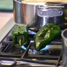 Para preparar las rajas, tostar los chiles sobre la lumbre directa de la hornilla dando vuelta con una pinza hasta que se vean negros por todas partes. Colocar dentro de una bolsa de plástico para que se suden durante 5 minutos. Retirar la piel quemada remojando la mano en agua cada vez que sea necesario. Cortar, por un lado, retirar semillas y venas y cortar la piel en rajas.