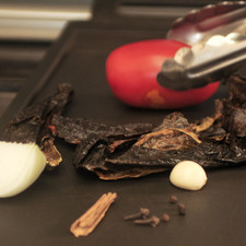 Desvenar los chiles y asarlos ligeramente sobre el comal junto con los clavos, las pimientas, la canela, el jitomate, la cebolla y el ajo.