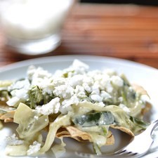 Servir los chilaquiles con rajas encima, espolvorear con cebolla picada y queso fresco.