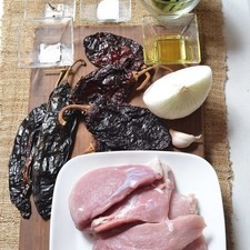 1 cucharita de sal 2 piezas de clavo de olor 1/2 pieza de cebolla blanca 2 cucharadas de aceite de oliva 1 pizca de bicarbonato de sodio 6 piezas de penca de nopal 2 piezas de chile ancho 2 piezas de chile pasilla 2 piezas de chile mulato 1 diente de ajo 500 gramos de pulpa de cerdo