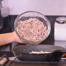 Calentar el sartén con el aceite de oliva durante 3 minutos. Agregar la cebolla y sofreír durante unos minutos, hasta que se vea transparente. Añadir la carne deshebrada y cocer unos minutos más.